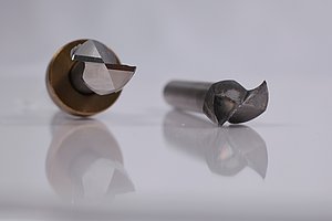 A comparison of two milling cutters: the one on the left is almost new, whilst the one on the right is clearly blunt and has notches.