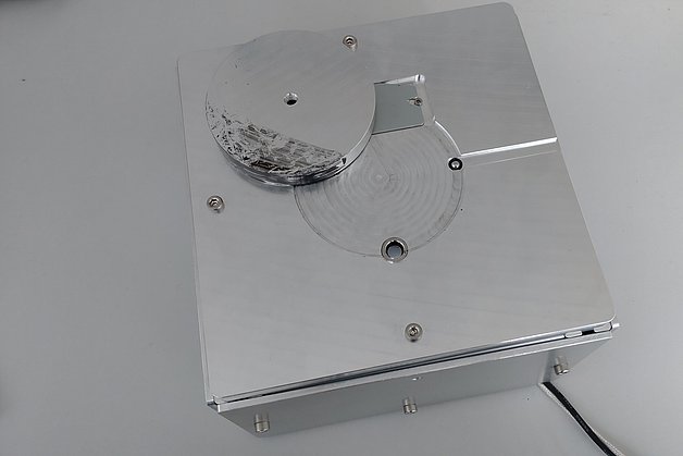 Helle Metallbox mit kleinen Öffnungen für Sensorik, Metallabdeckung und einem Kabel.