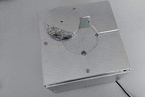 Helle Metallbox mit kleinen Öffnungen für Sensorik, Metallabdeckung und einem Kabel.