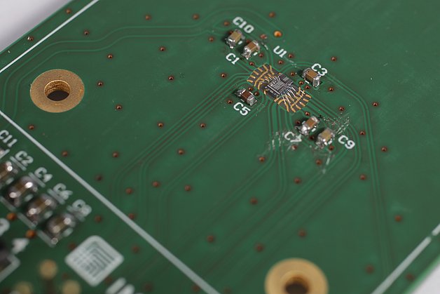 A circuit board with an unencapsulated microelectronic chip, leaving the bond wires and chip structures visible 