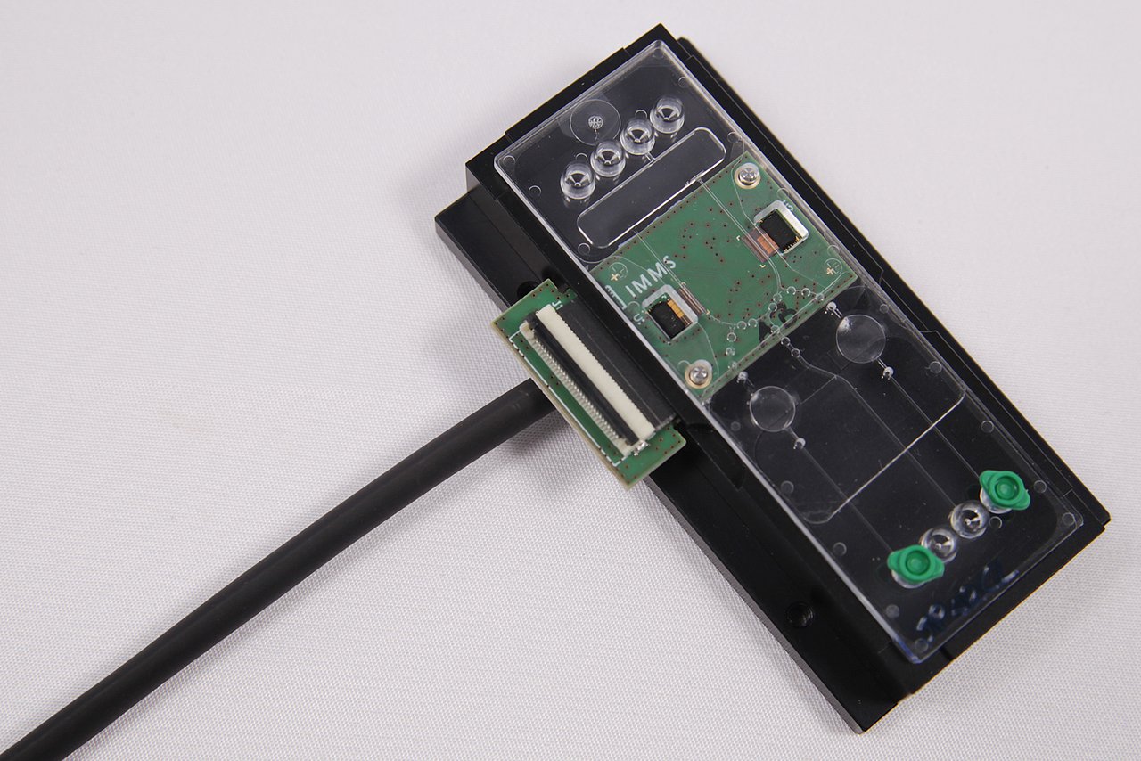 Leiterplatte mit Mikroelektronik-Chip in einem Gehäuse mit Mikrofluidik-Kanälen.