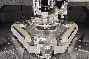 Komplexe Konstruktion aus Glas-, Metall-, Elektronik- und Pneumatikkomponenten auf einem Granitblock.