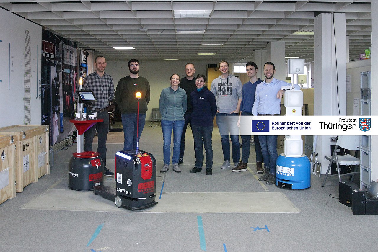 Das Projektteam aus acht Personen steht hinter drei autonomen Robotern. 