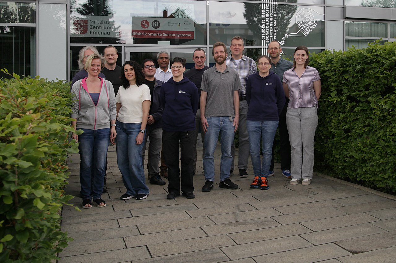 Mechatronics department at the headquarters in Ilmenau. Photograph: IMMS. Eight men and five women in front of the IMMS building in Ilmenau.
